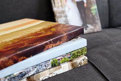 Stack of canvas prints with varied images on sofa