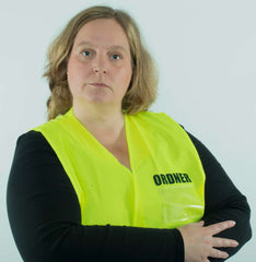 Woman in neon yellow safety vest labeled 'ORDNER'