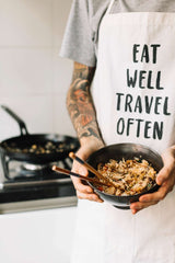 Person holding wok with stir-fried rice and chopsticks