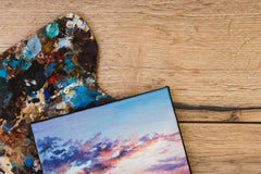 Colorful artist palette and sunset landscape painting