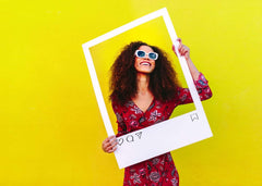 Joyful woman in red floral dress holding white frame
